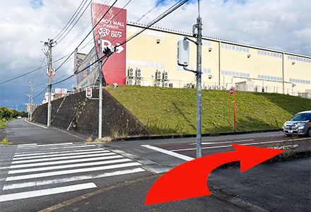 シュロアモールの看板を目印に信号を渡って右折します。